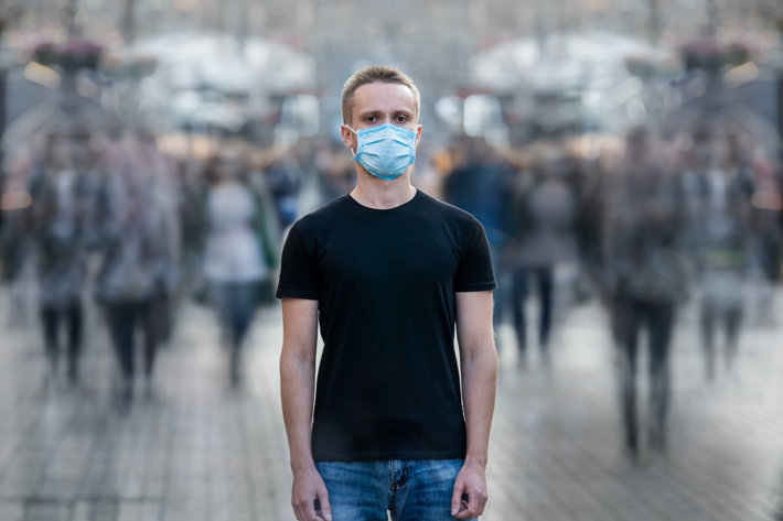 Man in a crowd in a facemask